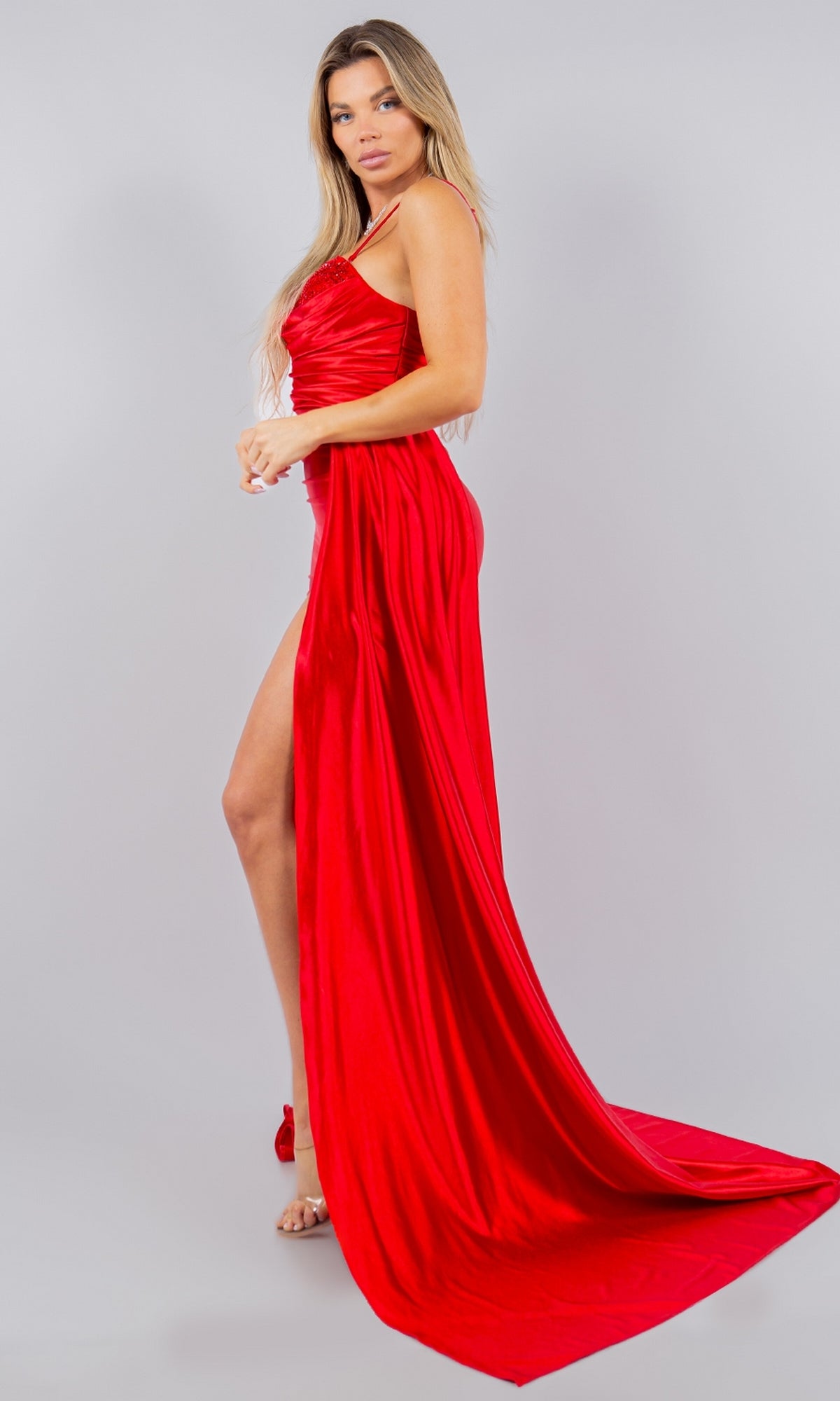 A woman in the Cinderella Couture 8082J Strapless Satin Prom Dress, floor-length with pleats, ruching, and a high slit, poses against a plain light grey background.